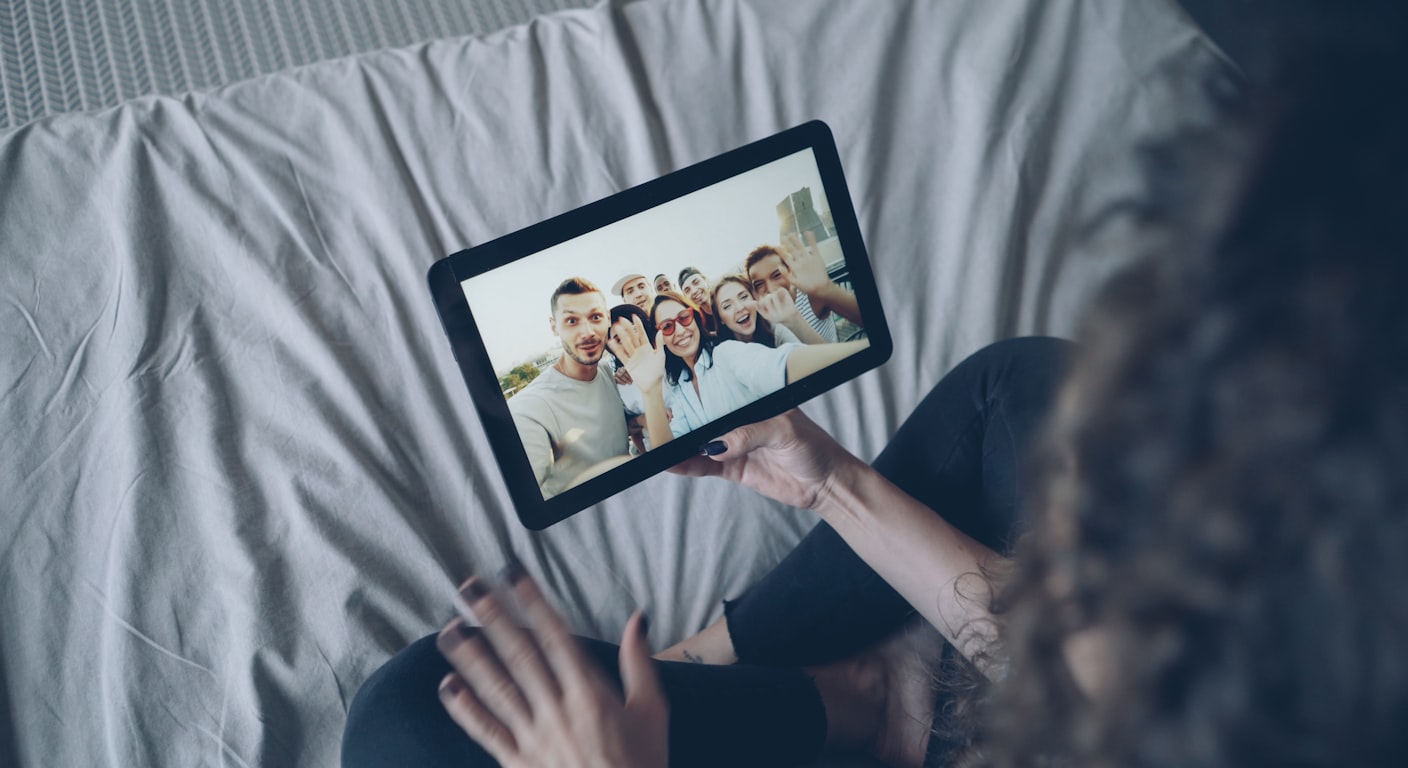 A person on a video call with a group of friends on a laptop screen.